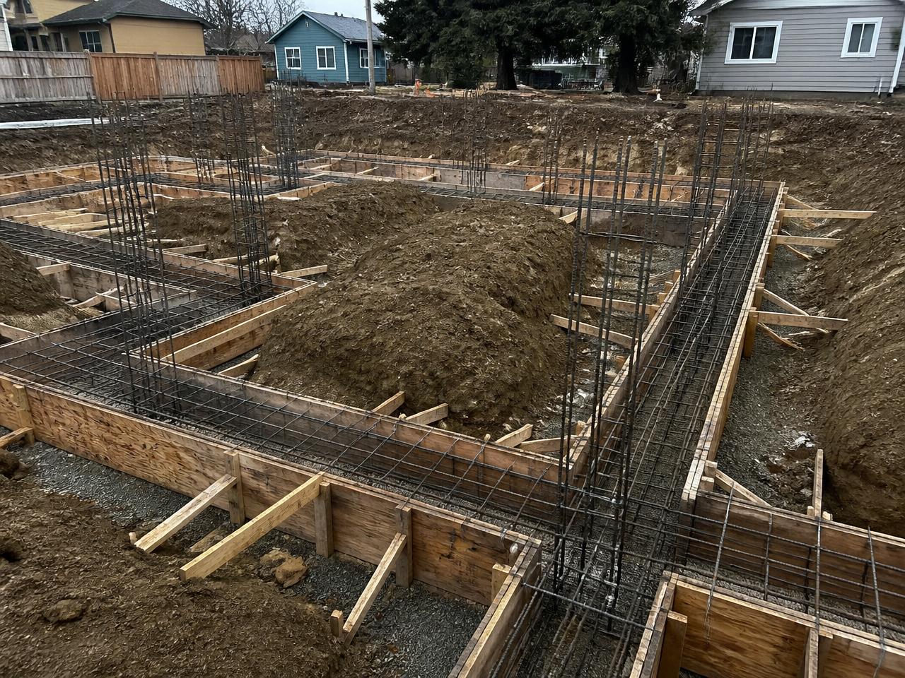 Concrete foundation formwork with rebar cages on an excavated site